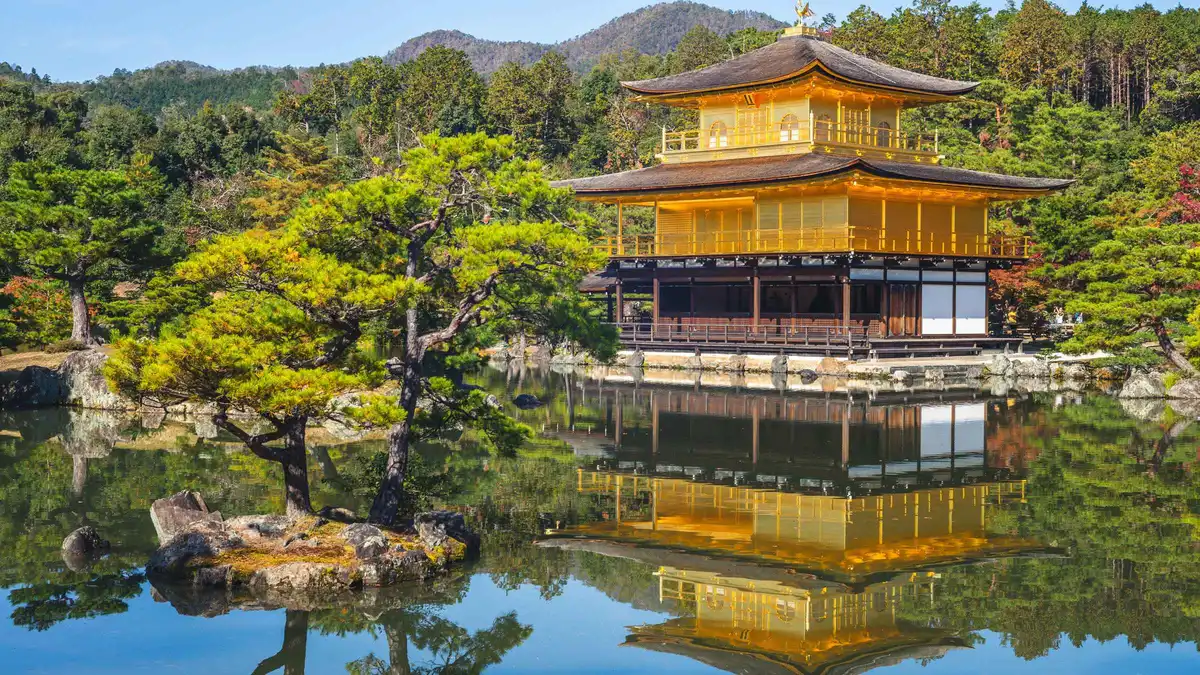 Monk leading visitors through a temple hall on a Kinkaku-ji and garden tour, Kyoto Japan
